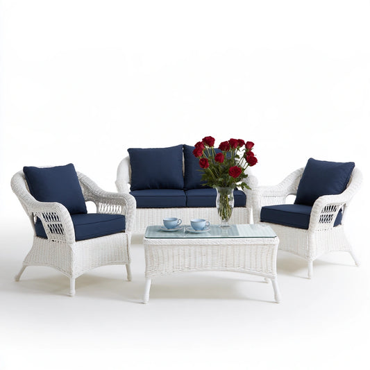 Ensemble de mobilier de jardin quatre pièces en rotin blanc, avec canapé et fauteuils, dans un espace extérieur.